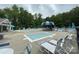 Relaxing community pool area surrounded by lush trees, lounge chairs, and shaded tables for a perfect summer day at 3933 Cameron Creek Dr, Matthews, NC 28105