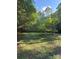 A large, grassy backyard is framed by mature trees at 400 Archibald Rd, Concord, NC 28025