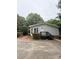 Features a charming home exterior with a wooden porch and steps, surrounded by mature trees and lush landscaping at 400 Archibald Rd, Concord, NC 28025