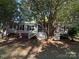 Charming home exterior features a screened in porch, with mature trees providing shade at 400 Archibald Rd, Concord, NC 28025