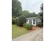 Shows a well-maintained home exterior with a wooden porch and steps, complemented by manicured landscaping and mulch beds at 400 Archibald Rd, Concord, NC 28025