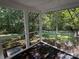 Enclosed screened porch showcasing stained wood flooring and a serene view of the backyard greenery at 400 Archibald Rd, Concord, NC 28025