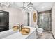 Opulent bathroom with gold sink bowls, decorative lighting, and a glass-enclosed shower at 435 S Tryon St, Charlotte, NC 28202