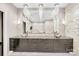 Bathroom with dual sinks, a large mirror, and stone accent wall, showcasing a modern aesthetic at 435 S Tryon St, Charlotte, NC 28202