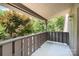 Private balcony with wood railings offering a serene view of the lush surrounding trees at 4725 Rounding Run Rd, Charlotte, NC 28277