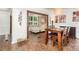 Dining area with hardwood floors, natural light, table for four, and open to a sitting room with stone wall at 4725 Rounding Run Rd, Charlotte, NC 28277