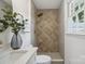 Modern bathroom features a stone-tiled walk-in shower and a stylish sink with updated faucet and decor at 5817 Red Carriage Ln, Charlotte, NC 28212