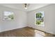 Bright, empty bedroom with hardwood floors and large windows offering abundant natural light and neighborhood views at 5817 Red Carriage Ln, Charlotte, NC 28212