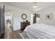 Light-filled bedroom with hardwood floors, a round mirror over dark wooden dresser, and a ceiling fan at 5817 Red Carriage Ln, Charlotte, NC 28212
