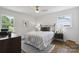 Bright bedroom featuring a black metal bed frame, a striped duvet cover, and dark wood flooring at 5817 Red Carriage Ln, Charlotte, NC 28212