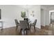 Dining area with a modern chandelier, a round table with four chairs, hardwood floors, and natural light at 5817 Red Carriage Ln, Charlotte, NC 28212