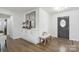 Stylish entryway with a bench, decorative mirror, and storage cabinet, complemented by hardwood floors and natural light at 5817 Red Carriage Ln, Charlotte, NC 28212