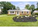 Charming brick home with a well-manicured front yard featuring lush landscaping and a healthy green lawn at 5817 Red Carriage Ln, Charlotte, NC 28212