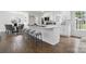 Bright and airy kitchen with a large island, bar seating, hardwood floors, and seamless flow to the dining area at 5817 Red Carriage Ln, Charlotte, NC 28212