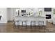 Stylish kitchen island with bar seating, seamlessly connecting the kitchen with modern appliances to the rest of the living space at 5817 Red Carriage Ln, Charlotte, NC 28212