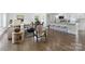 Open-concept living space with hardwood floors, modern furnishings, and seamless flow to the dining area and kitchen at 5817 Red Carriage Ln, Charlotte, NC 28212