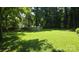 Large backyard featuring an above ground pool, luscious green grass, and mature trees at 5832 Thompson Rd, Charlotte, NC 28216