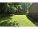 Expansive, grassy backyard with privacy fence and mature trees at 5832 Thompson Rd, Charlotte, NC 28216