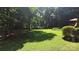 Lush backyard featuring mature trees, green lawn, and partial view of above ground pool at 5832 Thompson Rd, Charlotte, NC 28216