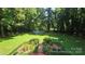 Spacious yard with above ground pool, mature trees, and beautiful landscaping perfect for outdoor living at 5832 Thompson Rd, Charlotte, NC 28216