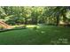 Spacious backyard with an above-ground pool, garden area, and green grass at 5832 Thompson Rd, Charlotte, NC 28216