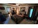 A bedroom featuring a bed, nightstands, decorative mirror, and window with curtains at 5832 Thompson Rd, Charlotte, NC 28216