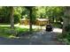 Exterior view of a house with a gravel driveway and mature trees at 5832 Thompson Rd, Charlotte, NC 28216