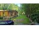 Charming log cabin-style home featuring a gravel driveway and mature trees at 5832 Thompson Rd, Charlotte, NC 28216