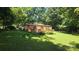 Home exterior with a spacious deck, well-manicured lawn, and a lush landscape at 5832 Thompson Rd, Charlotte, NC 28216
