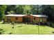 Charming, wood-sided home with a screened-in porch, surrounded by lush greenery and a well-manicured lawn at 5832 Thompson Rd, Charlotte, NC 28216