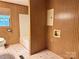 Bathroom with tile floor, window, shower, toilet, and wood paneling at 613 Catawba St, Chester, SC 29706