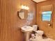 Bathroom with vintage sink, toilet, mirror and wood paneling at 613 Catawba St, Chester, SC 29706