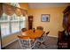 Dining room features tan carpet, yellow walls, a grandfather clock, and large window at 613 Stacy Ridge Rd, Gastonia, NC 28052