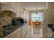Kitchen featuring white cabinets and appliances with an eat in dining area and wallpaper at 613 Stacy Ridge Rd, Gastonia, NC 28052