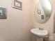 Clean half-bath with pedestal sink, round mirror, and framed art at 739 Elders Story Rd, Fort Mill, SC 29708