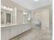 Elegant bathroom with double vanity, subway tile shower and marble floors at 7732 Waverly Walk Ave, Charlotte, NC 28277