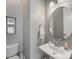 Clean half-bathroom features stylish pedestal sink, round mirror, and attractive wall art at 7732 Waverly Walk Ave, Charlotte, NC 28277
