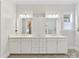 Bright bathroom featuring a double vanity, large mirrors, and white cabinetry at 7732 Waverly Walk Ave, Charlotte, NC 28277
