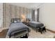 Neutral-toned bedroom with two beds, wood floors, and unique wallpaper at 7732 Waverly Walk Ave, Charlotte, NC 28277