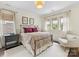 Bright bedroom featuring large windows and a bed with decorative floral bedding at 7732 Waverly Walk Ave, Charlotte, NC 28277