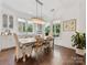 Dining room with hardwood floors, a chandelier, and large windows offering natural light at 7732 Waverly Walk Ave, Charlotte, NC 28277