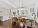 Open floorplan dining room with decorative chandelier over farm table and access to modern kitchen at 7732 Waverly Walk Ave, Charlotte, NC 28277