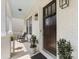 Charming front porch featuring a dark wood door, potted plants, and stylish lighting fixtures at 7732 Waverly Walk Ave, Charlotte, NC 28277