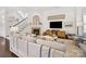 Bright living room with stone fireplace, large tv, hardwood floors, and staircase access at 7732 Waverly Walk Ave, Charlotte, NC 28277