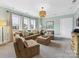 Relaxing living room with a large brown couch, and a decorative light fixture at 7732 Waverly Walk Ave, Charlotte, NC 28277
