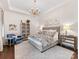 Spacious main bedroom with elegant chandelier, tray ceiling, and sitting area at 7732 Waverly Walk Ave, Charlotte, NC 28277