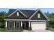 Charming home featuring dark siding, a welcoming front porch, and a two car garage at 909 Exeter Dr, Sherrills Ford, NC 28673