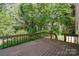 Back deck nestled amongst lush greenery offers a private outdoor retreat at 9701 Kent Village Dr, Charlotte, NC 28269