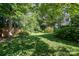Green backyard featuring mature trees, and a shed perfect for outdoor activities and relaxation at 9701 Kent Village Dr, Charlotte, NC 28269
