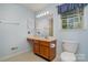 Bright bathroom featuring vanity, toilet, mirror, and window at 9701 Kent Village Dr, Charlotte, NC 28269